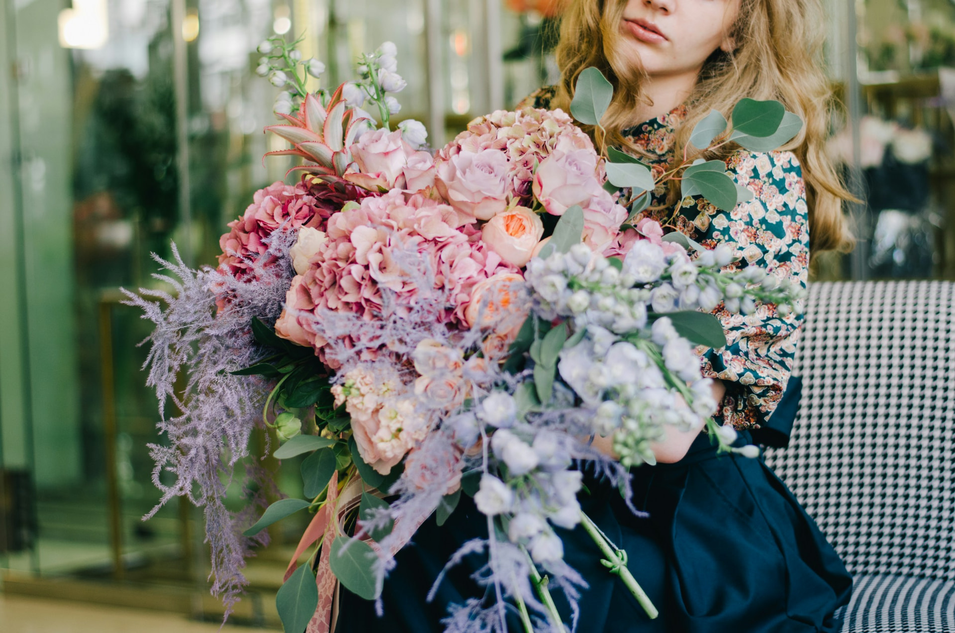 Woman holding an abundant romantic pink floral arrangement