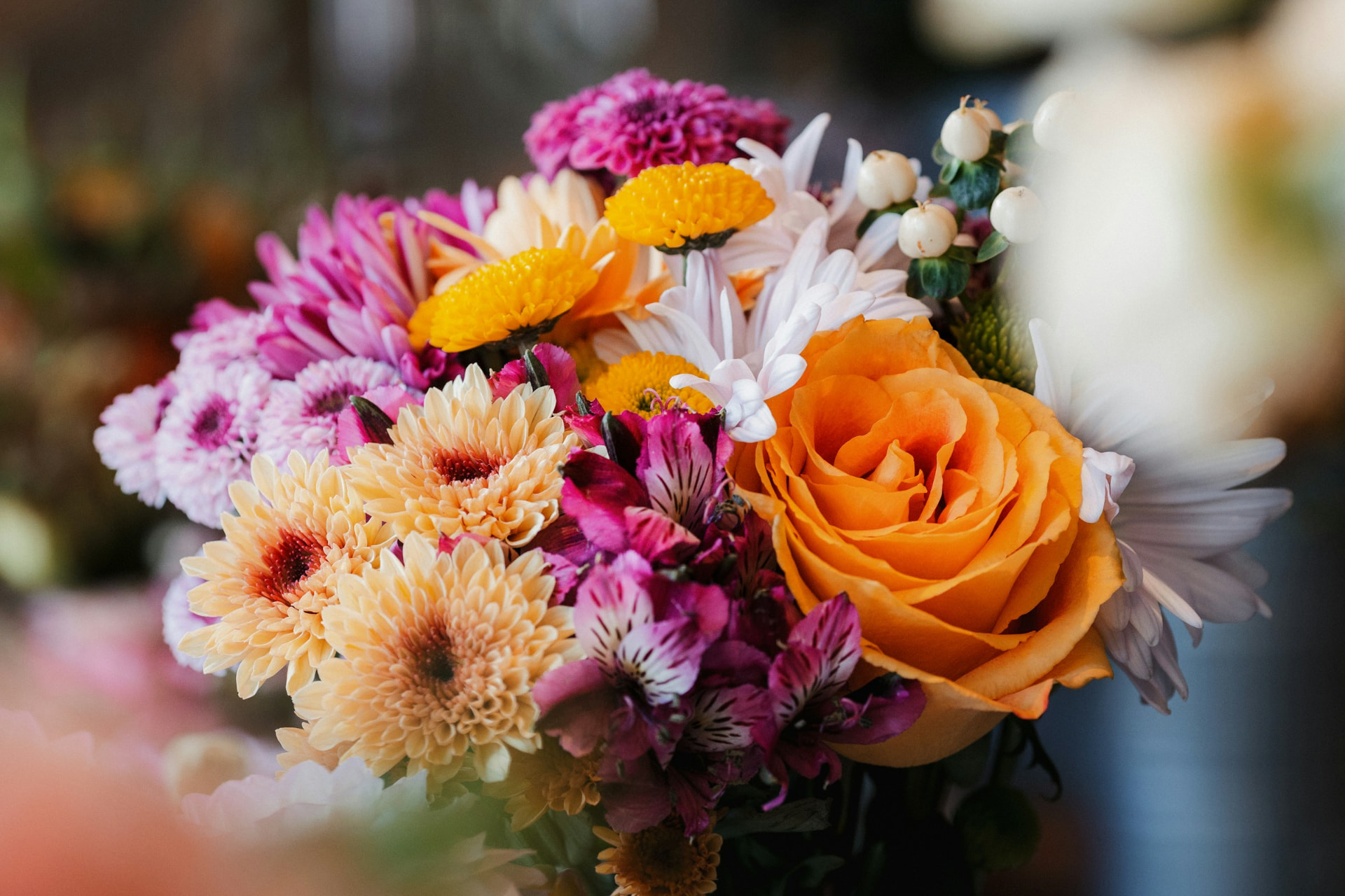 Colorful arrangement with orange roses and pink flowers